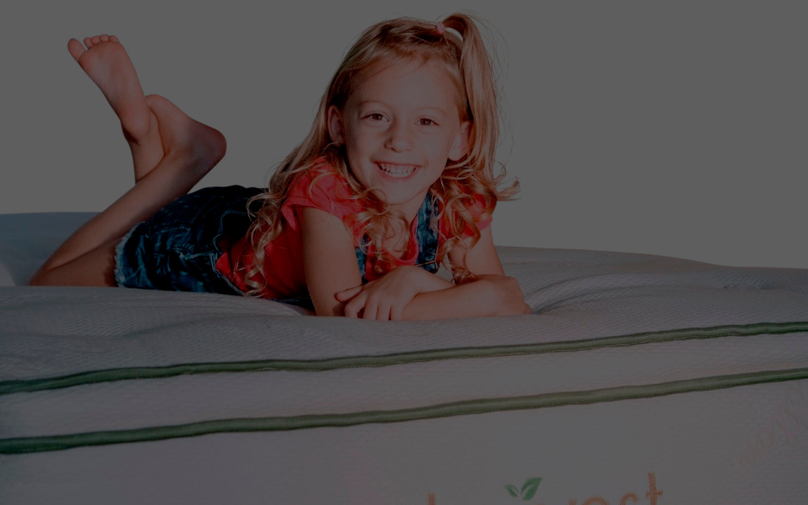 Little Girl laying on our Harvest Pillow top mattress smiling 