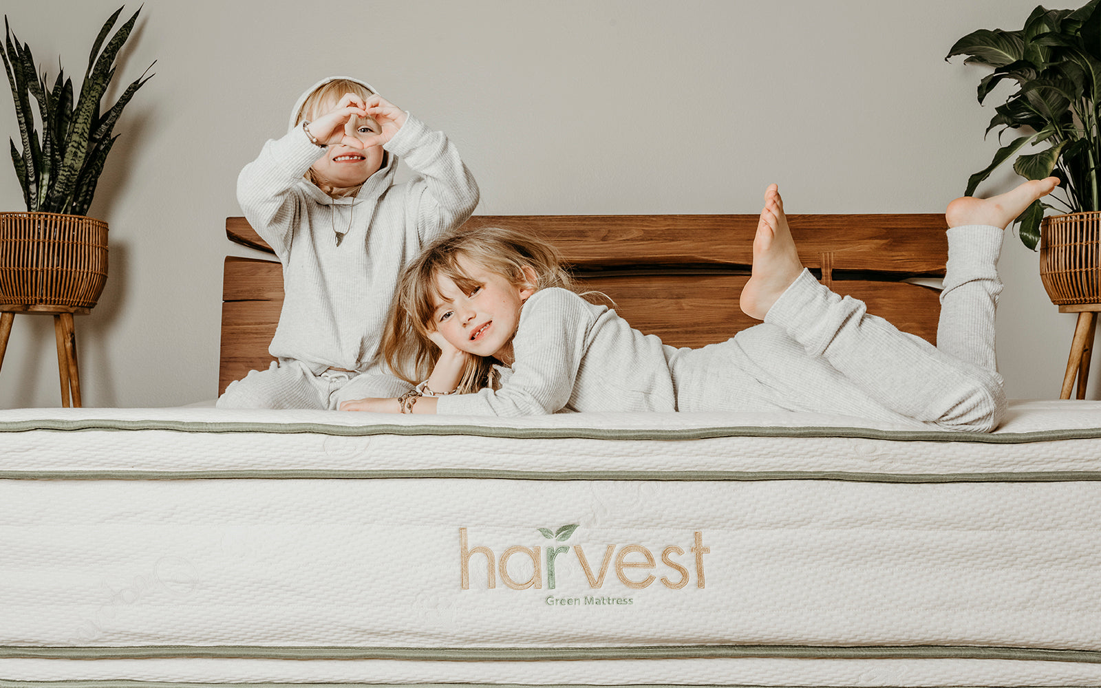 2 Kids on lying on our Harvest green double-sided pillow top mattress.  Text states Certifiably Certified.