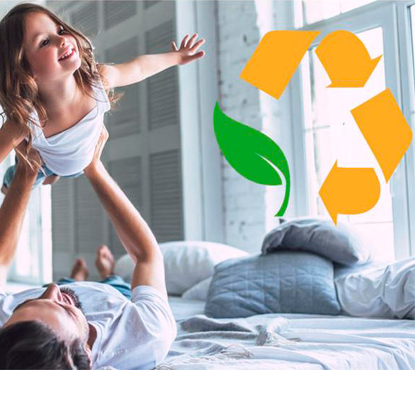 Father and daughter playing on our mattress with our environmentally safe logo overlayed