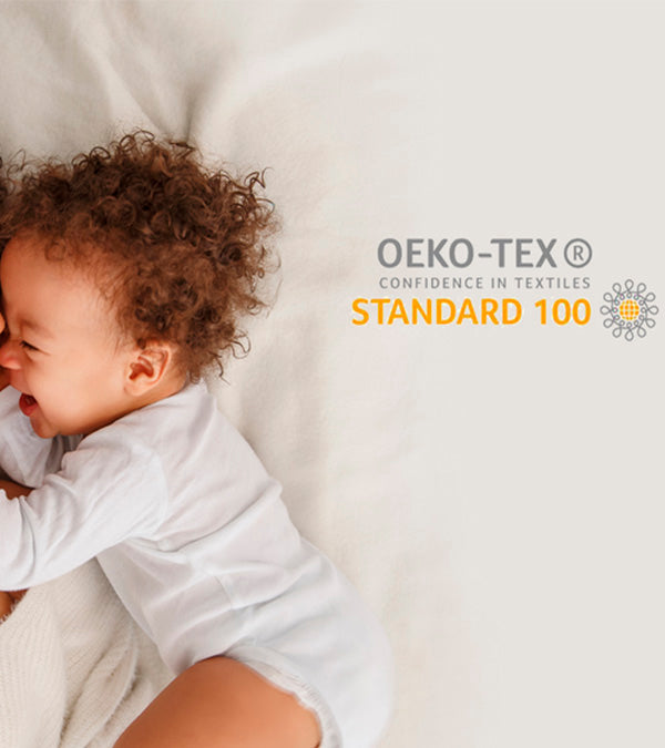 Infant laying on our mattress with the OEKO-TEX certification logo