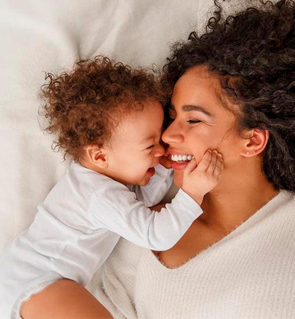 Mom with infant laying on top of one of our mattresses that does not contain any chemical adhesives